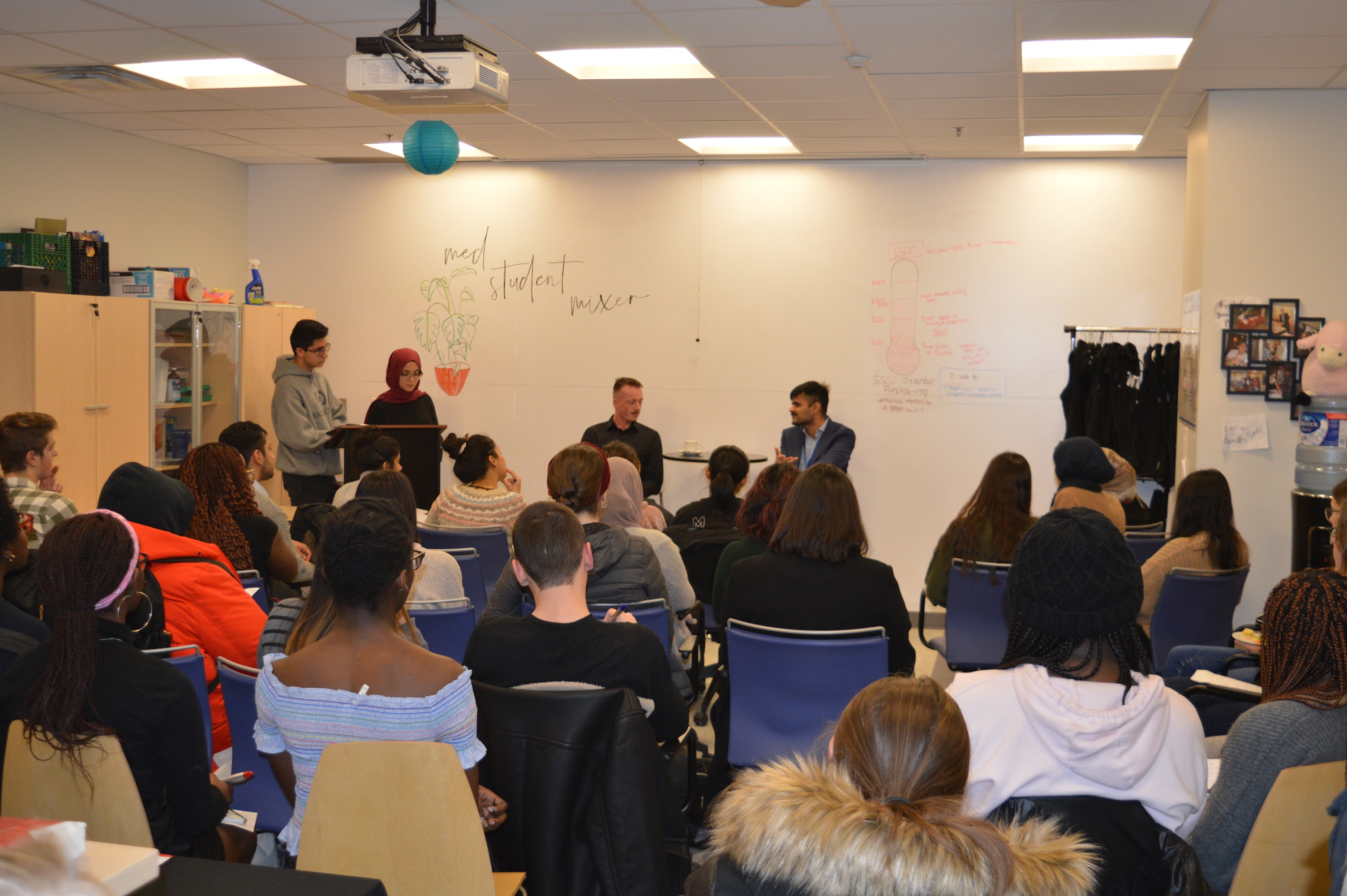 a large panel discussion with the two visiting med students